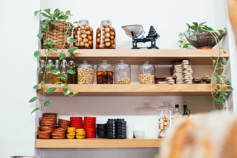 Organized small kitchen with open shelving and storage containers