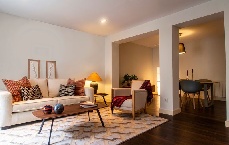 Cozy living room with sofa, armchair and warm lamplight